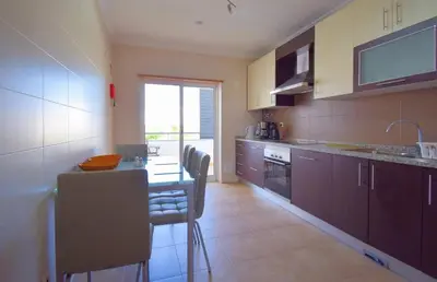 a kitchen with a table and chairs and a counter top at Perfect New Apartment in Albufeira in Albufeira