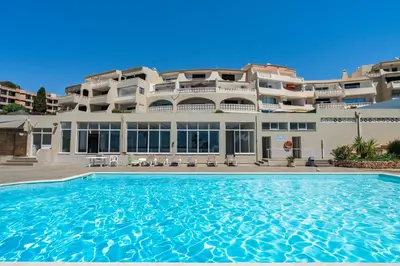 a hotel with a swimming pool in front of a building at Aveiros by the Sea by Intiholidays in Albufeira