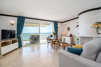 a living room with a television and a table with chairs at Aveiros by the Sea by Intiholidays in Albufeira