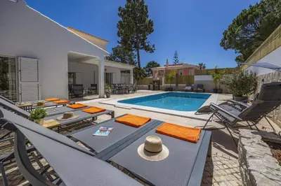 a backyard with a swimming pool and a house at Villa Falesia Blue by Villa Plus in Olhos de Água