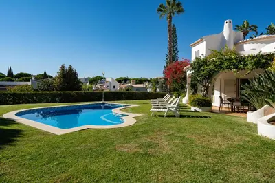 a yard with a swimming pool and a house at Casa de Gales - Vilamoura in Vilamoura