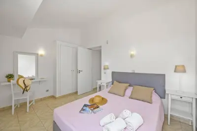 a bedroom with a pink bed with towels on it at Villa Amendoeira by Villa Plus in Albufeira