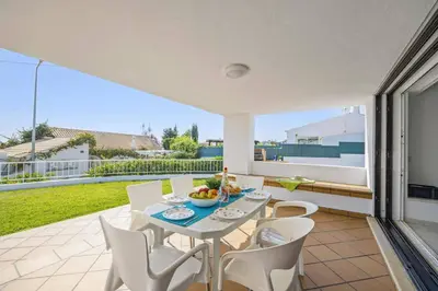a dining room with a table and chairs on a patio at Villa Amendoeira by Villa Plus in Albufeira