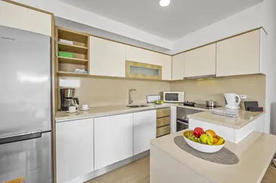 a kitchen with white cabinets and a bowl of fruit on a counter at Villa Amendoeira by Villa Plus in Albufeira