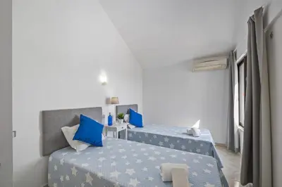 a bedroom with two beds with blue pillows at Villa Amendoeira by Villa Plus in Albufeira