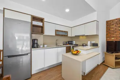 a kitchen with white cabinets and a stainless steel refrigerator at Villa Buganvillea by Villa Plus in Albufeira