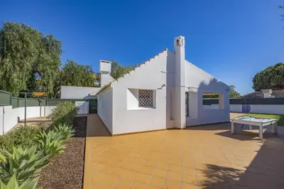 a white house with a table on a patio at Villa Buganvillea by Villa Plus in Albufeira
