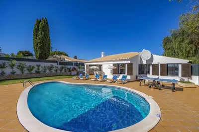 a swimming pool in front of a house at Villa Buganvillea by Villa Plus in Albufeira
