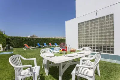 a living room with a table and a dining room at Villa Marina Azul by Villa Plus in Albufeira