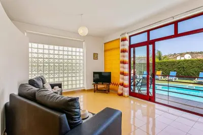 a living room with a couch and a tv and a pool at Villa Marina Azul by Villa Plus in Albufeira