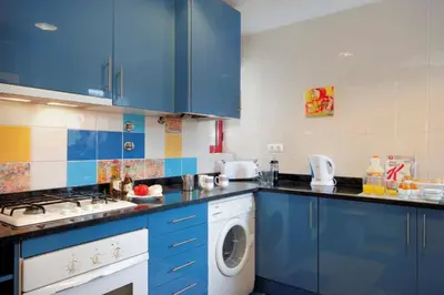 a kitchen with blue cabinets and a washing machine at Villa Marina Azul by Villa Plus in Albufeira