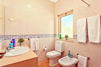 a bathroom with a sink and a toilet and a mirror at Villa Susana by Villa Plus in Albufeira