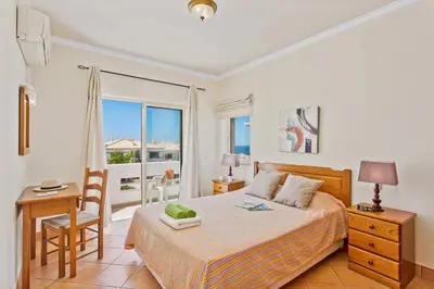 a bedroom with a bed and a desk and a window at Villa Susana by Villa Plus in Albufeira