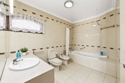 a bathroom with a toilet and a sink and a tub at Villa Zea by Villa Plus in Albufeira