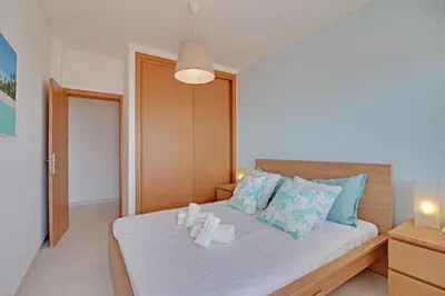 a bedroom with a bed with towels on it at Quarteira Beach & Ocean View by Homing in Quarteira