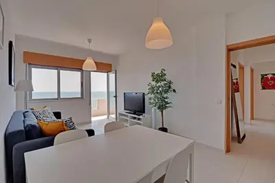 a living room with a couch and a table and a tv at Quarteira Beach & Ocean View by Homing in Quarteira