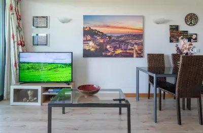 a living room with a television and a table at Residence Golf Club-Vilamoura-Algarve in Vilamoura