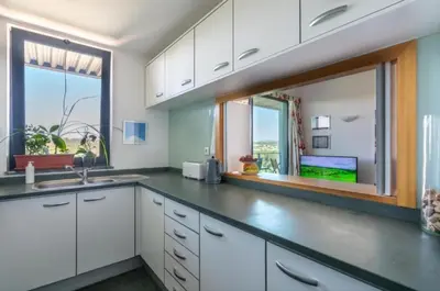 a kitchen with white cabinets and a large window at Residence Golf Club-Vilamoura-Algarve in Vilamoura