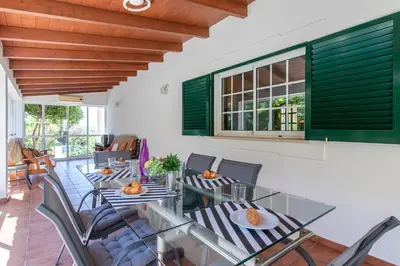 a patio with tables and chairs and green shutters at Monte das Palmeiras in Loulé