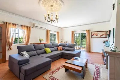 a living room with a couch and a table at Monte das Palmeiras in Loulé
