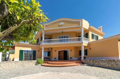 a large yellow house with a porch at Monte das Palmeiras in Loulé
