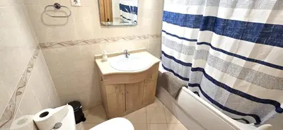 a bathroom with a sink and a tub and a mirror at Holidays - Albufeira in Albufeira