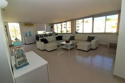 a living room with white furniture and large windows at Happy Place - Albufeira in Albufeira