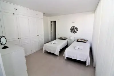 two beds in a white room with white cabinets at Happy Place - Albufeira in Albufeira