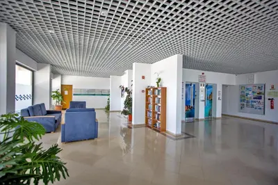 a hospital lobby with blue chairs and a ceiling at Sea View Apartment - 3 Swimming Pool & Fitness in Albufeira