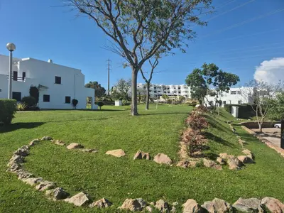 a park with rocks and a tree and a building at Casa Anna Del Rey. sth.faceing with free wifi. in Albufeira