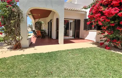 a house with a garden with red flowers at Villa Pedro - Swimming Pool - BY BEDZY in Albufeira