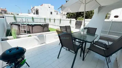 a patio with a table and chairs and an umbrella at Casa da Praia by Sunny Deluxe in Albufeira