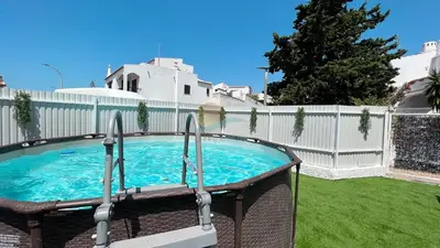 a swimming pool in a backyard with a white fence at Casa da Praia by Sunny Deluxe in Albufeira