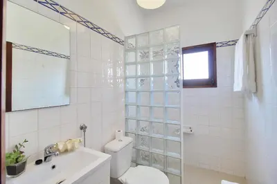 a white bathroom with a toilet and a sink at Apt 1 Quarto, Piscina, AC, Varanda, Prestige For Home in Vilamoura