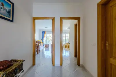 a hallway with two doors and a dining room at Grevilias in Vilamoura