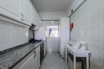 a kitchen with white cabinets and a counter top at Grevilias in Vilamoura