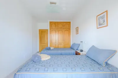 a bedroom with two beds with blue sheets at Grevilias in Vilamoura