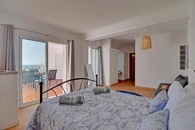 a bedroom with a bed with a view of a balcony at Casa Roos Loïs in Albufeira