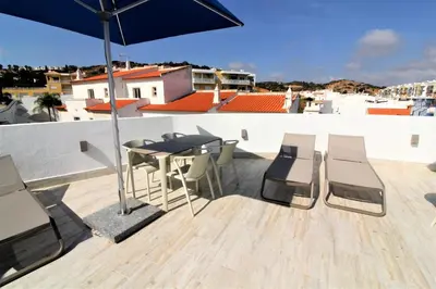 a table and chairs on a balcony with an umbrella at Historic Centre B - Albufeira in Albufeira