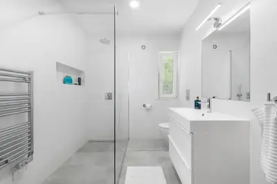 a white bathroom with a sink and a shower at Villa Saragoça in Loulé