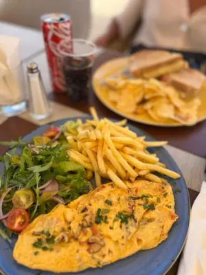 a blue plate of food with french fries and an omelet at Apartamento Surpresa in Albufeira