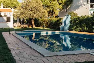 a swimming pool in a yard next to a house at Falésia 25 in Albufeira