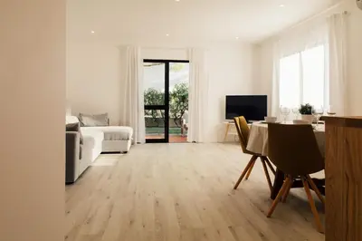 a white living room with a table and a couch at Falésia 25 in Albufeira