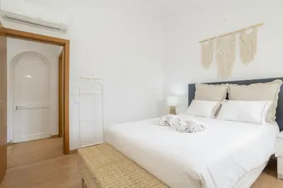 a bedroom with a large white bed with white pillows at Hopstays Vilamoura Aldeia do Golfe - House C3 in Vilamoura