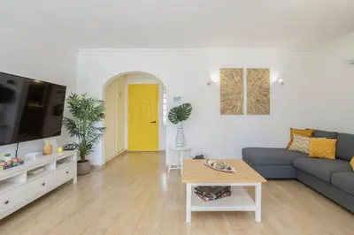 a living room with a blue couch and a yellow door at Hopstays Vilamoura Aldeia do Golfe - House C3 in Vilamoura
