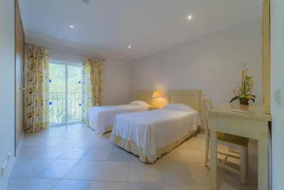a bedroom with two beds and a desk and a window at Villa Bota by Garvetur in Almancil