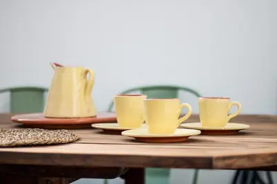 a wooden table with cups and saucers on it at Bambu Villa in Albufeira