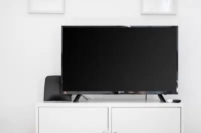 a flat screen tv sitting on top of a white cabinet at Bambu Villa in Albufeira