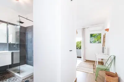 a bathroom with a glass shower and a green chair at Bambu Villa in Albufeira