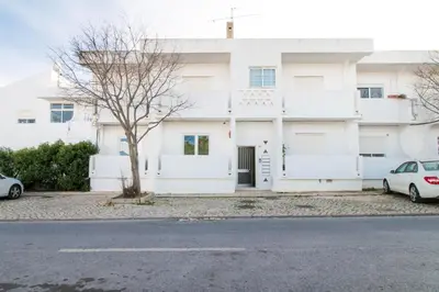 a white house with a car parked in front of it at Bambu Villa in Albufeira